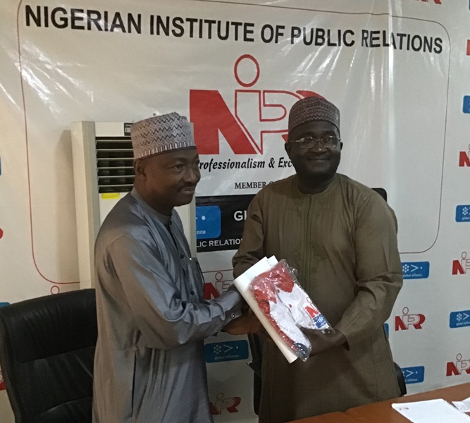 Executive Secretary Centre for Crisis Communication, Air Commodore Yusuf Anas, Rtd (L) receiving a package from the President, Nigerian Institute of Public Relations (NIPR) Mallam Mukhtar Sirajo, in Abuja